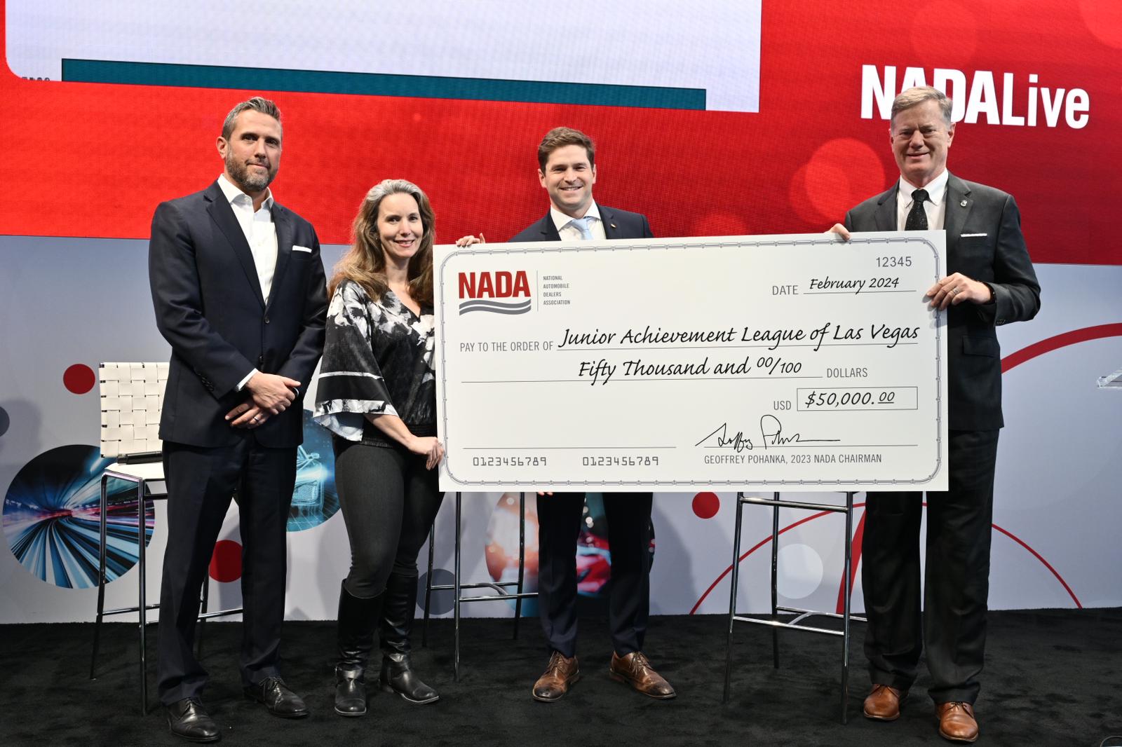 people on stage holding a check