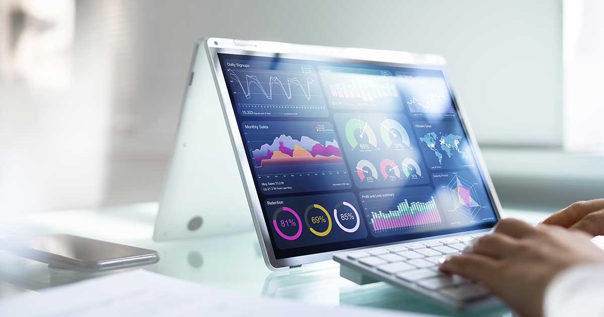 A man types on a laptop computer showing a data graphic