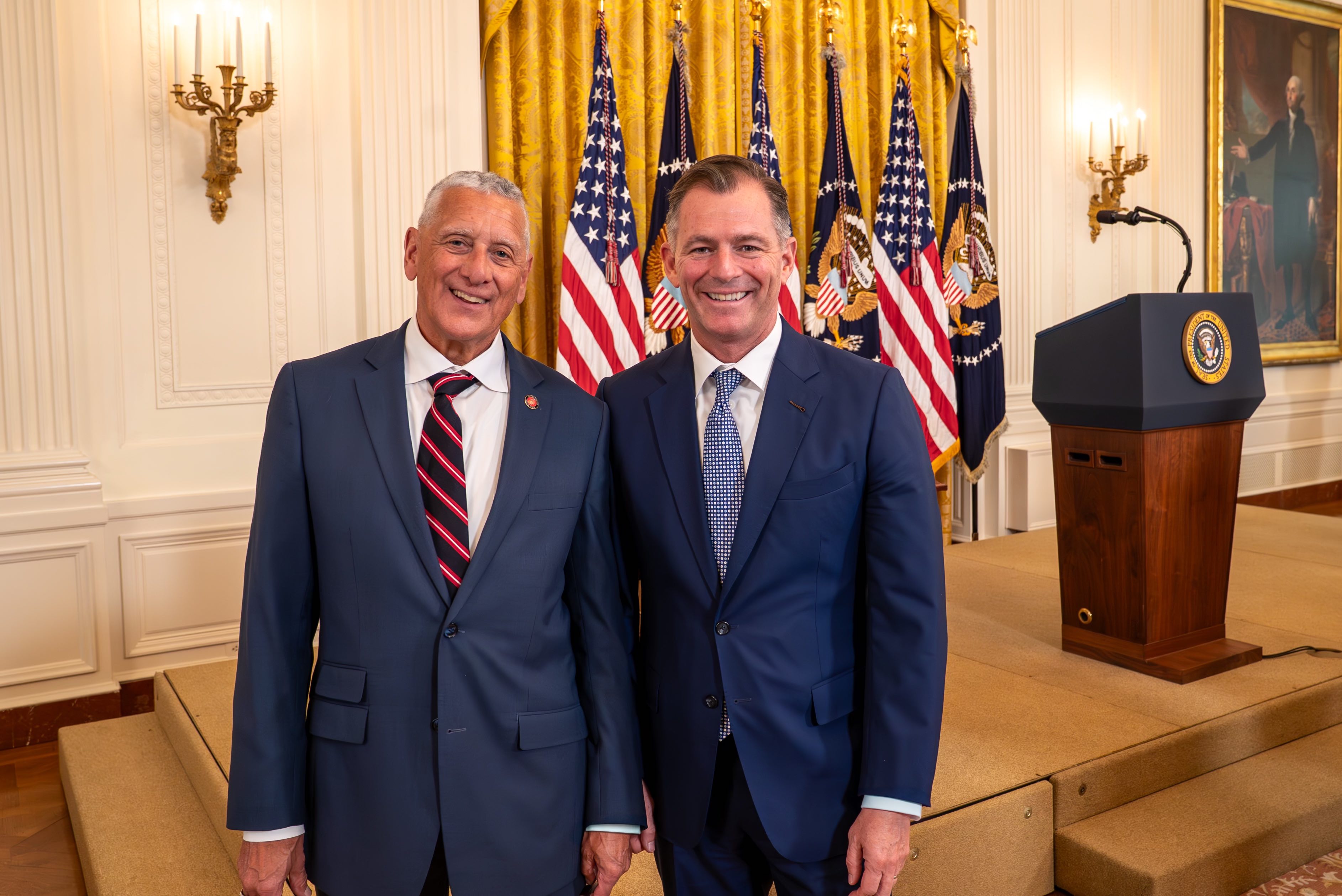 two men standing at white house